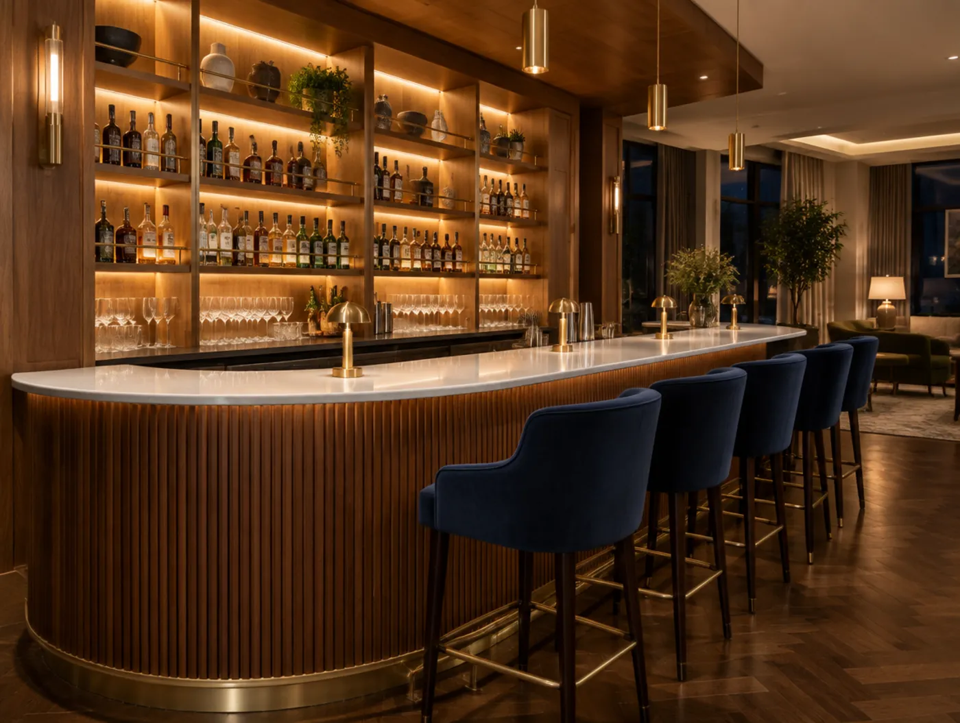 A hotel bar with a fluted walnut bar front and backlit oak shelving